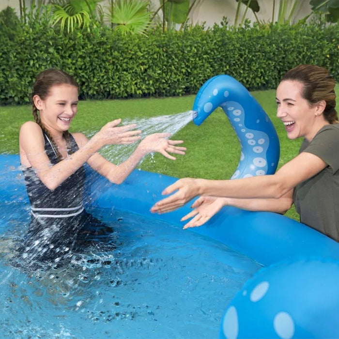 Woman and girl playing in blue octopus inflatable pool with sprayer in backyard garden