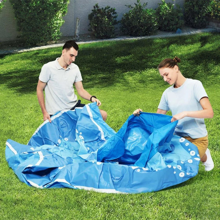 Two people assembling a blue inflatable octopus pool on grass outdoors