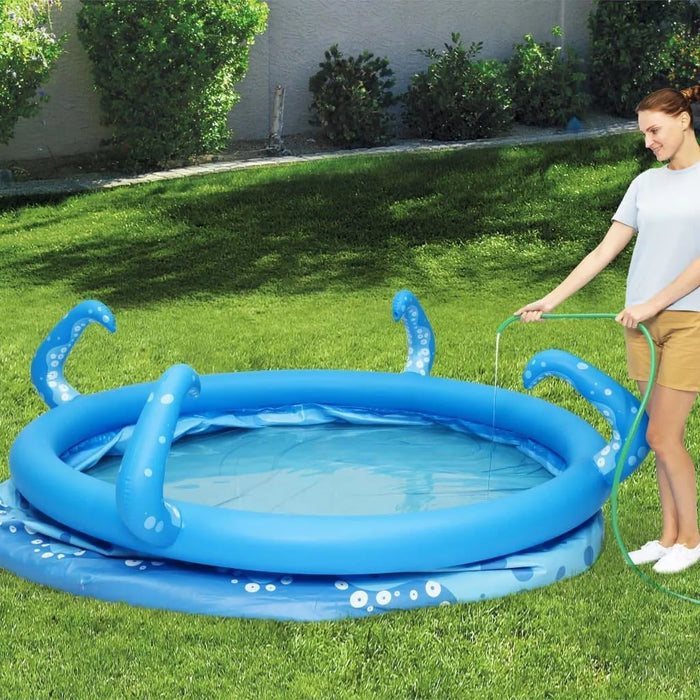 Woman filling blue inflatable octopus pool with sprayer tentacles on green lawn outdoors