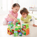 Two toddlers playing with colorful Montessori stacking cubes, educational toy set indoors