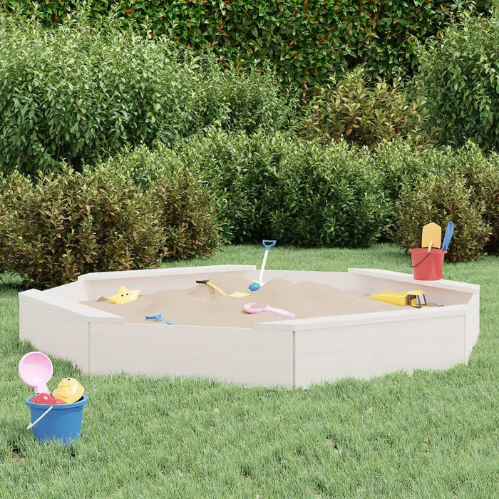 Large square white wooden sandbox with four seats and sand toys in a grassy backyard