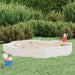 Large square white wooden sandbox with four seats and sand toys in a grassy backyard