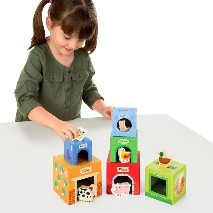 Girl playing with colorful farm animal stacking cubes toy featuring animals, numbers, and colors.