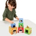 Girl playing with colorful farm animal stacking cubes toy featuring animals, numbers, and colors.