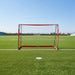 Foldable portable football goal with red frame on green soccer field