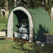 Green taffeta storage tent outdoors with duffel bags and camping gear inside
