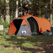 Grey and orange taffeta camping tent for 3 persons set up in a forested campsite.