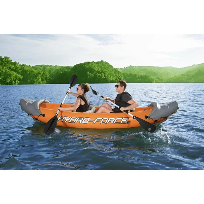Two people paddling Hydro-Force Rapid X2 inflatable kayak on a lake with green hills