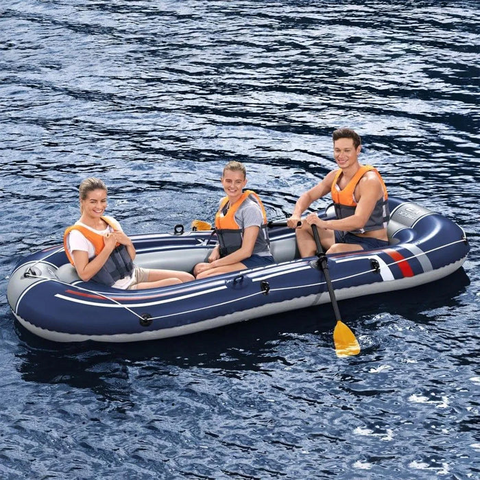 Three people in a blue Hydro-Force Treck X3 inflatable boat on water, wearing life jackets