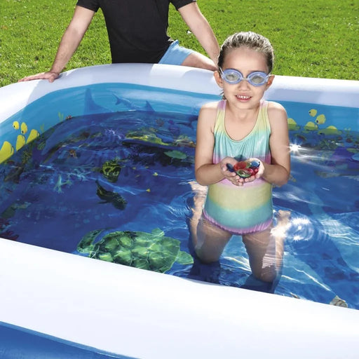 Girl in goggles holding crystals in inflatable 3D undersea adventure pool outdoors