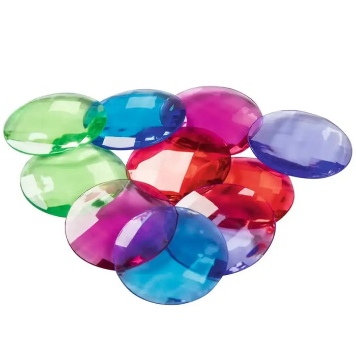 Colorful translucent plastic gems in green, blue, red, and purple on a white background