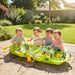 Four children playing with jungle adventure water play table sensory set outdoors