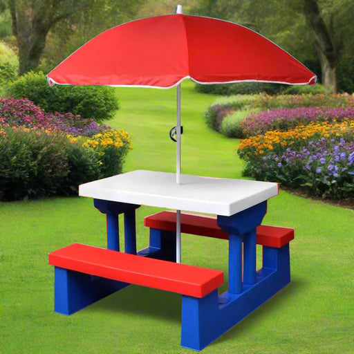 Kids picnic table with red umbrella and benches in a colorful outdoor garden.