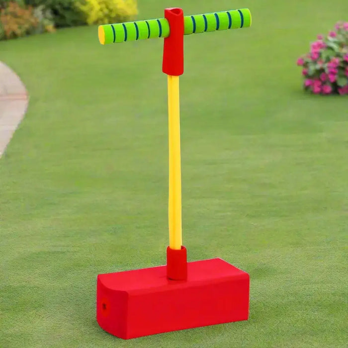 Kids pogo stick jumper with red soft foam base on green grass lawn