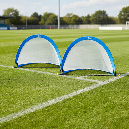 Set of two blue pop-up football goals on a grass soccer field corner
