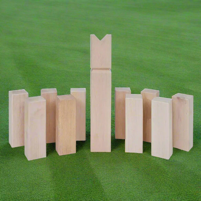 Traditional Swedish Kubb game wooden pieces arranged on green grass outdoors