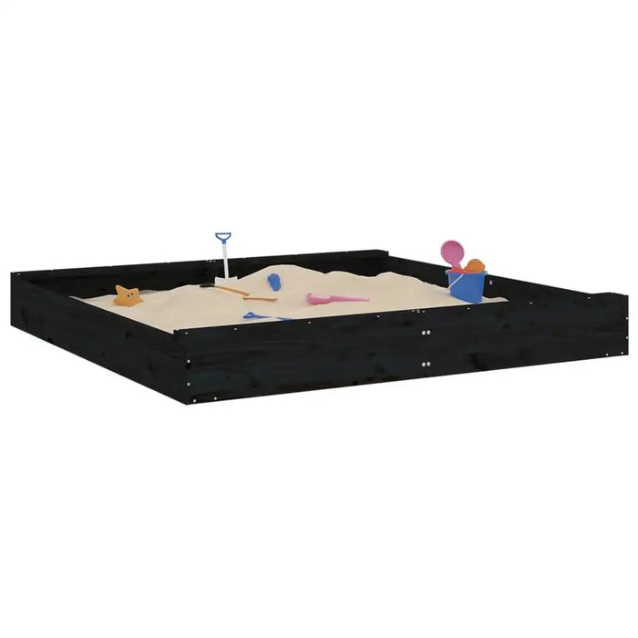 Large square black wooden sandbox with sand toys and built-in seats on white background