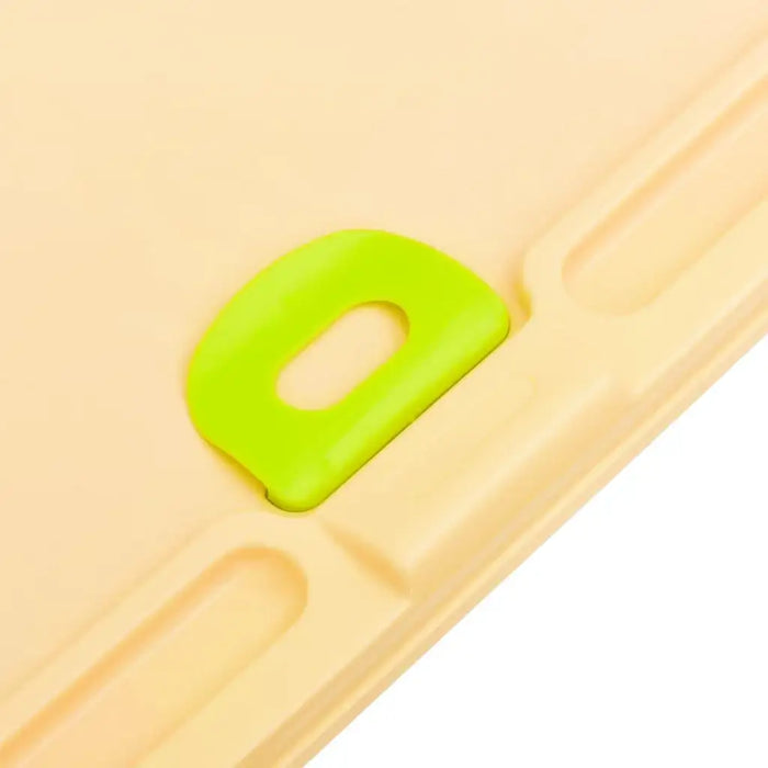 Closeup of beige children’s learning desk with green plastic handle