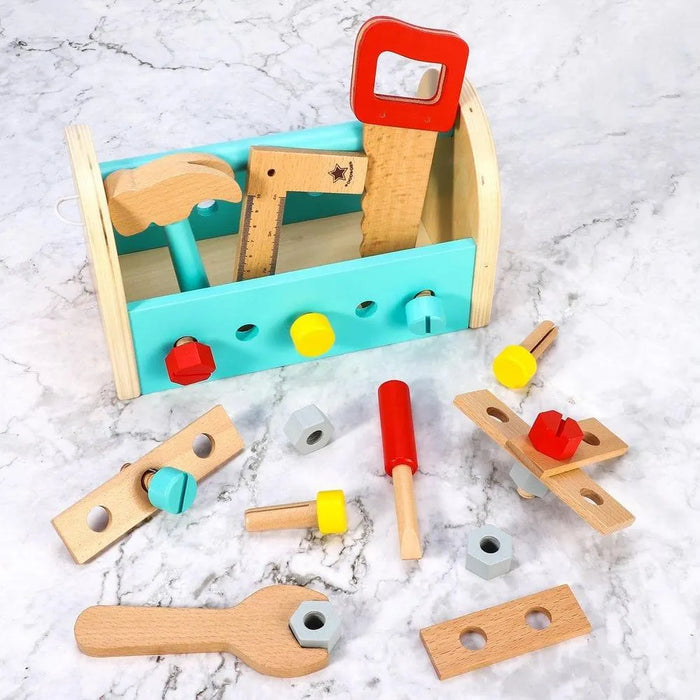 Wooden toy toolbox set with hammer, wrench, saw, ruler, bolts and nuts on marble surface