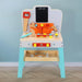 Wooden kids workbench with toy tools, bolts, and colorful storage bins against blue wall