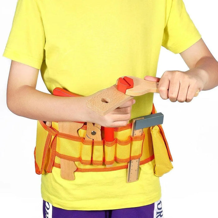 Child wearing yellow shirt and tool belt with wooden toy DIY tools set