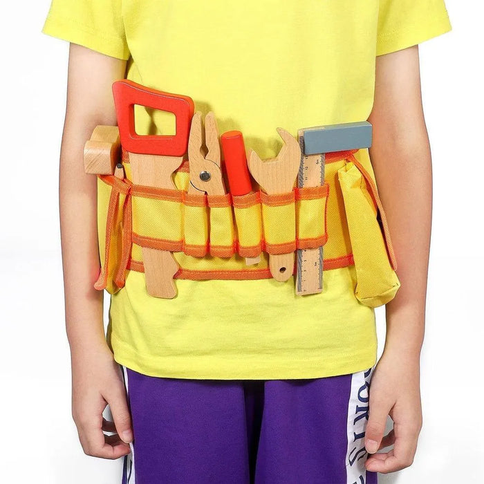 Child wearing yellow toy tool belt with wooden tools and ruler against white background