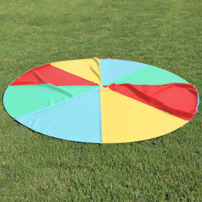 Round rainbow play parachute with colorful panels on grass, outdoor group activity game