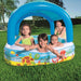 Kids playing in inflatable pool with canopy and colorful sea animal design outdoors