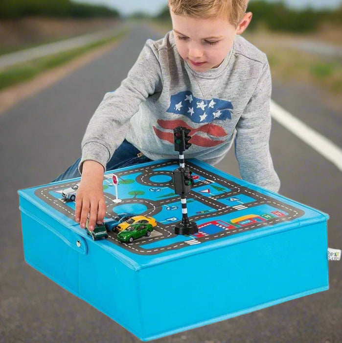Child playing with foldable blue toy garage and road playmat set featuring cars and traffic light