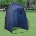 Blue portable camping toilet privacy tent set up outdoors on green grass with trees in background
