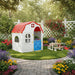 Portable folding kids playhouse with red roof and blue door in a colorful garden setting