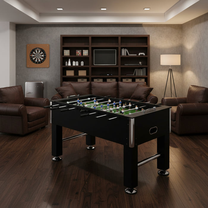 Black professional football table with adjustable height in modern game room with leather chairs