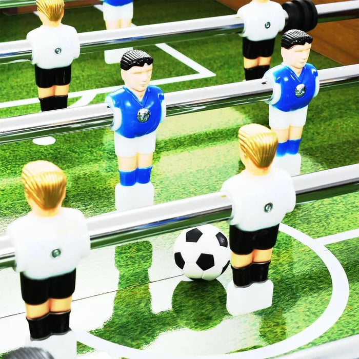 Close-up of foosball table with blue and white player figures and a soccer ball on green pitch