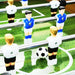 Close-up of foosball table with blue and white player figures and a soccer ball on green pitch