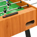 Wood finish professional foosball table with black score tracker and green field