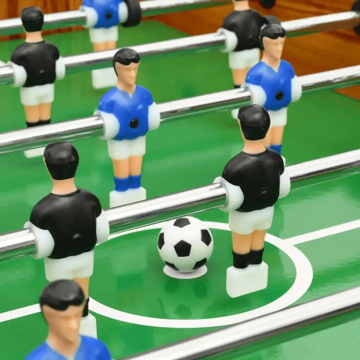 Close-up of competition grade foosball table with black and blue player figures and soccer ball