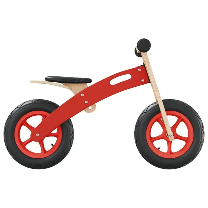 Red wooden balance bike with adjustable seat and black tires on white background