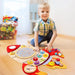 Boy playing with rocket-shaped space-themed wooden activity board on floor