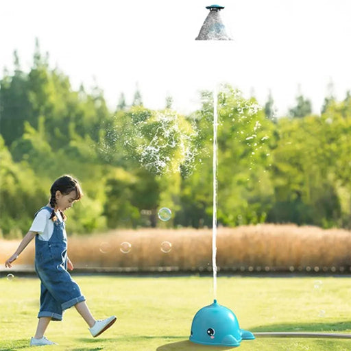 Child playing outdoors with spinning whale water sprinkler spraying tall water jets