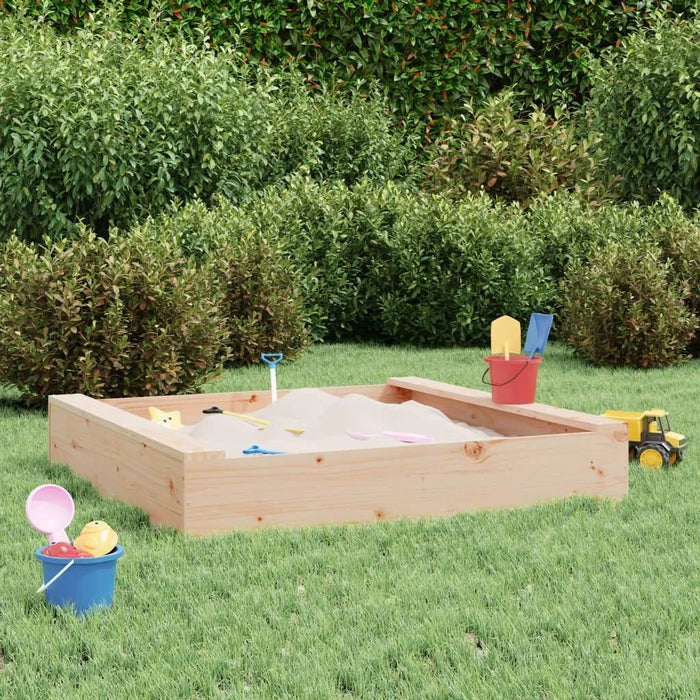 Square wooden sandbox with seats, toys, and buckets on green grass in a garden setting