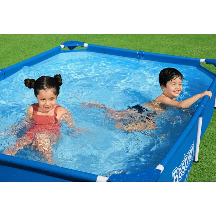 Two kids play in a blue Bestway steel pro swimming pool on green grass.