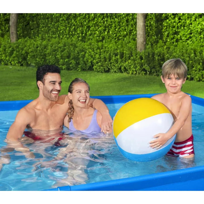 Family enjoying a Bestway Steel Pro swimming pool with a beach ball in a green backyard.