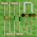Traditional wooden croquet set with mallets, balls, hoops, and stakes on green grass