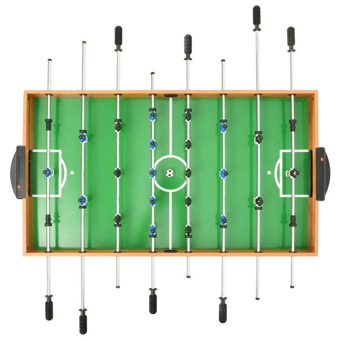Tabletop foosball game on green field in wooden frame, family multi-game table