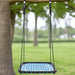 Blue web garden swing seat with adjustable ropes and hooks hanging from a tree outdoors