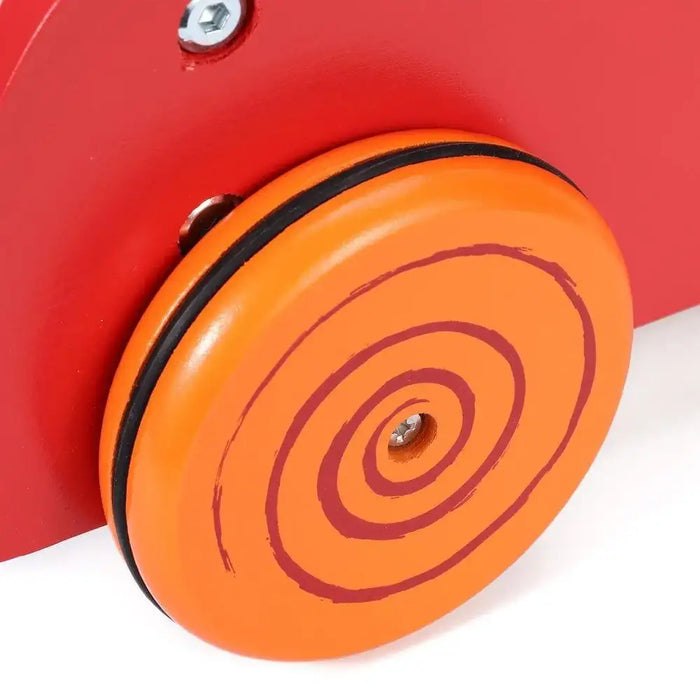 Close-up of orange wooden wheel with red swirl on a red baby walker toy