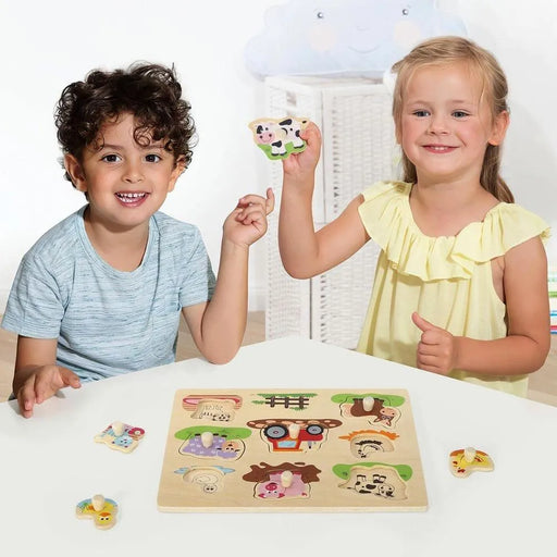 Children playing with a wooden farm animals puzzle peg board featuring animals and a tractor