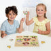 Children playing with a wooden farm animals puzzle peg board featuring animals and a tractor