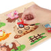 Hand placing tractor piece in wooden farm animals peg puzzle board with animals and fence