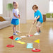 Kids playing indoors with wooden mini golf set, clubs, obstacles, and colorful flags